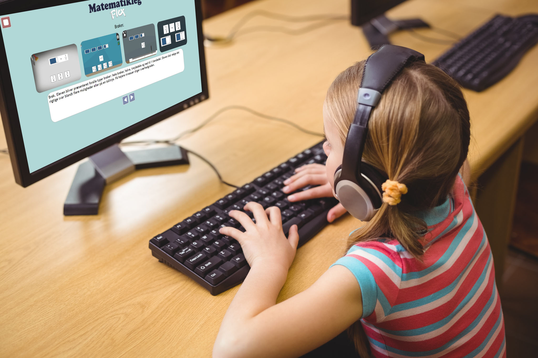 Pige sidder ved en computer og træner matematikopgaver 